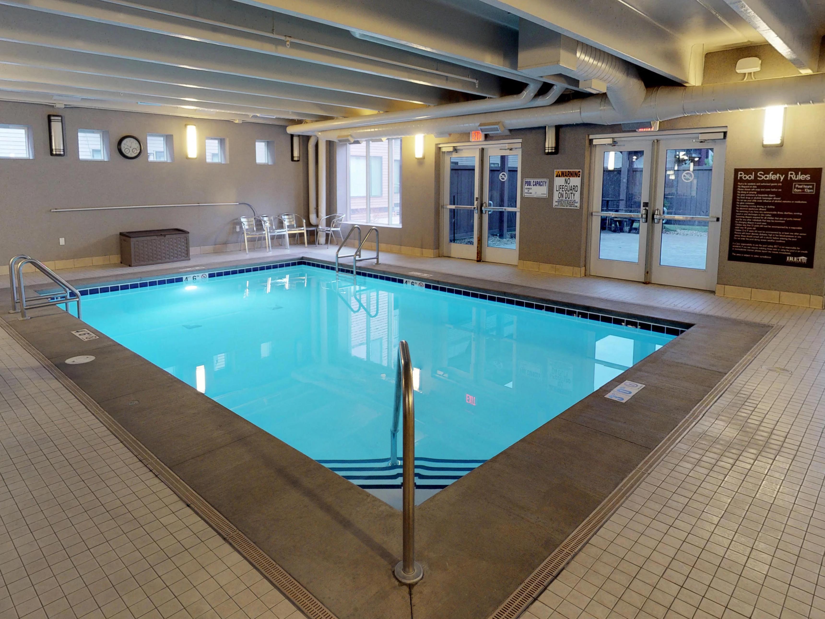 Indoor pool available year round with glass doors leading outside to the community grills.